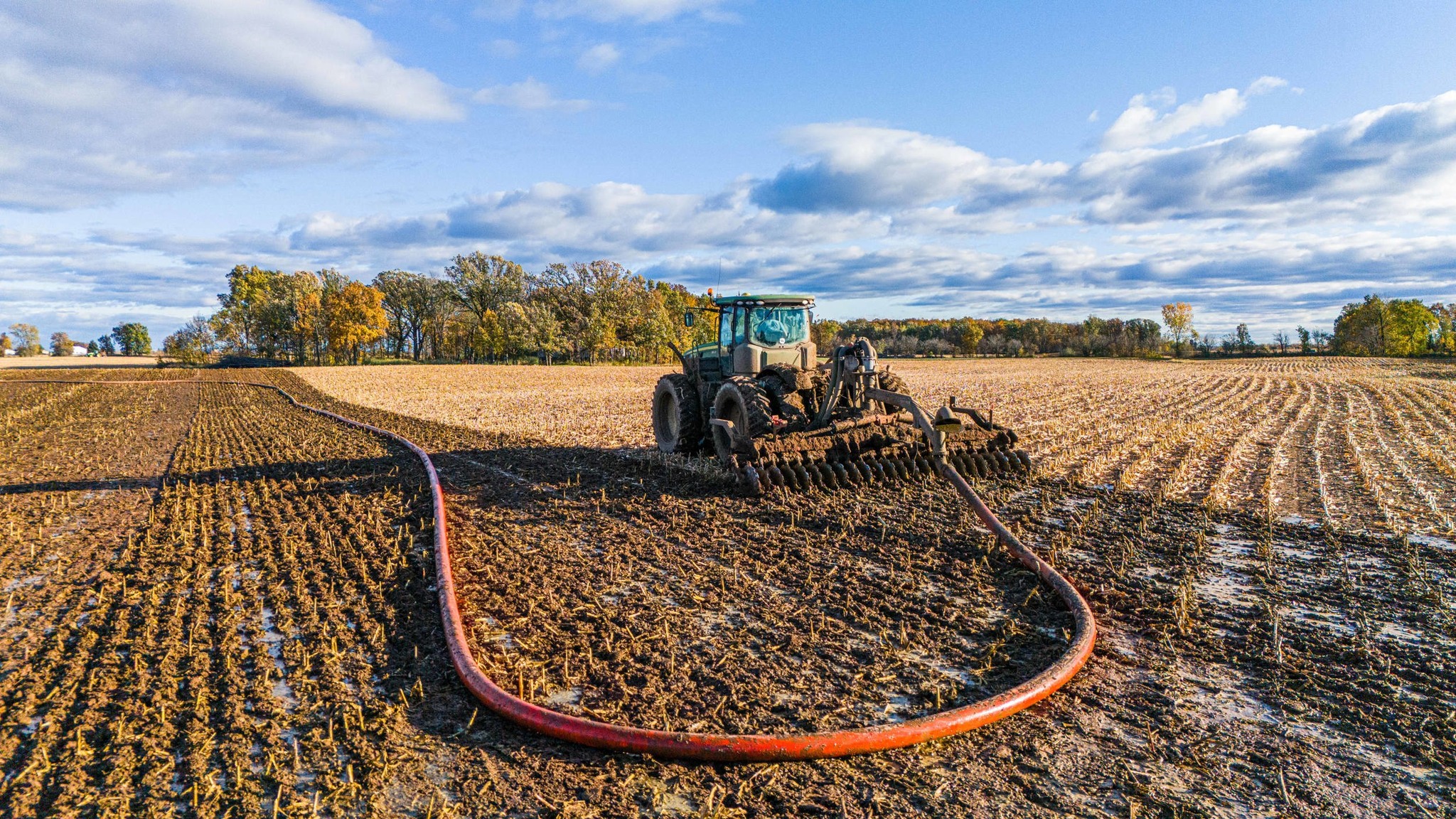 Manure pumping equipment in action with dragline hoses, designed for efficient and sustainable field application.