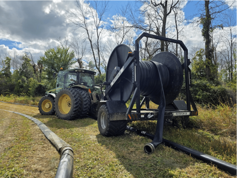 Tractor with dragline hose reel setup for efficient manure pumping and field application at Phil’s Pumping & Fabrication.