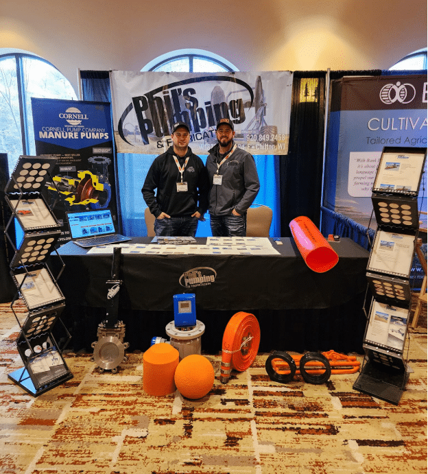 Phil’s Pumping & Fabrication team at trade show showcasing manure pumps, dragline systems, and farming solutions.
