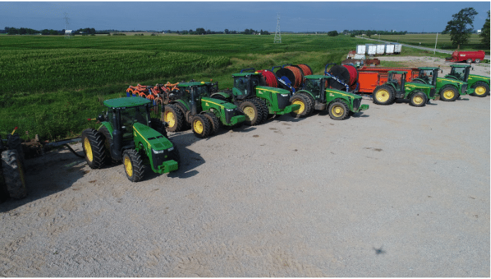 Modern manure tractors and hose reels lined up for efficient dairy farm nutrient management operations.
