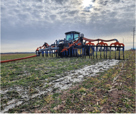 Tractor applying manure with drag hose system, ensuring even nutrient distribution and reduced soil compaction.