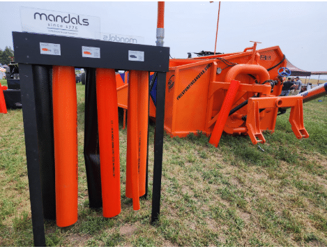 Mandals layflat manure hoses and pumping accessories displayed at agricultural equipment fair.