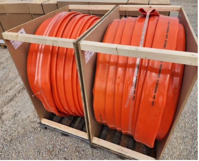 Mandals drag hose neatly coiled in crates, designed for durable and reliable manure dragline pumping systems.