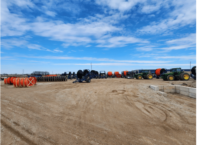 Manure application equipment and drag hose reels stored in an open farm yard for dragline pumping systems.