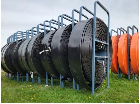 Properly stored manure hoses on racks in the field ready for use in manure application.